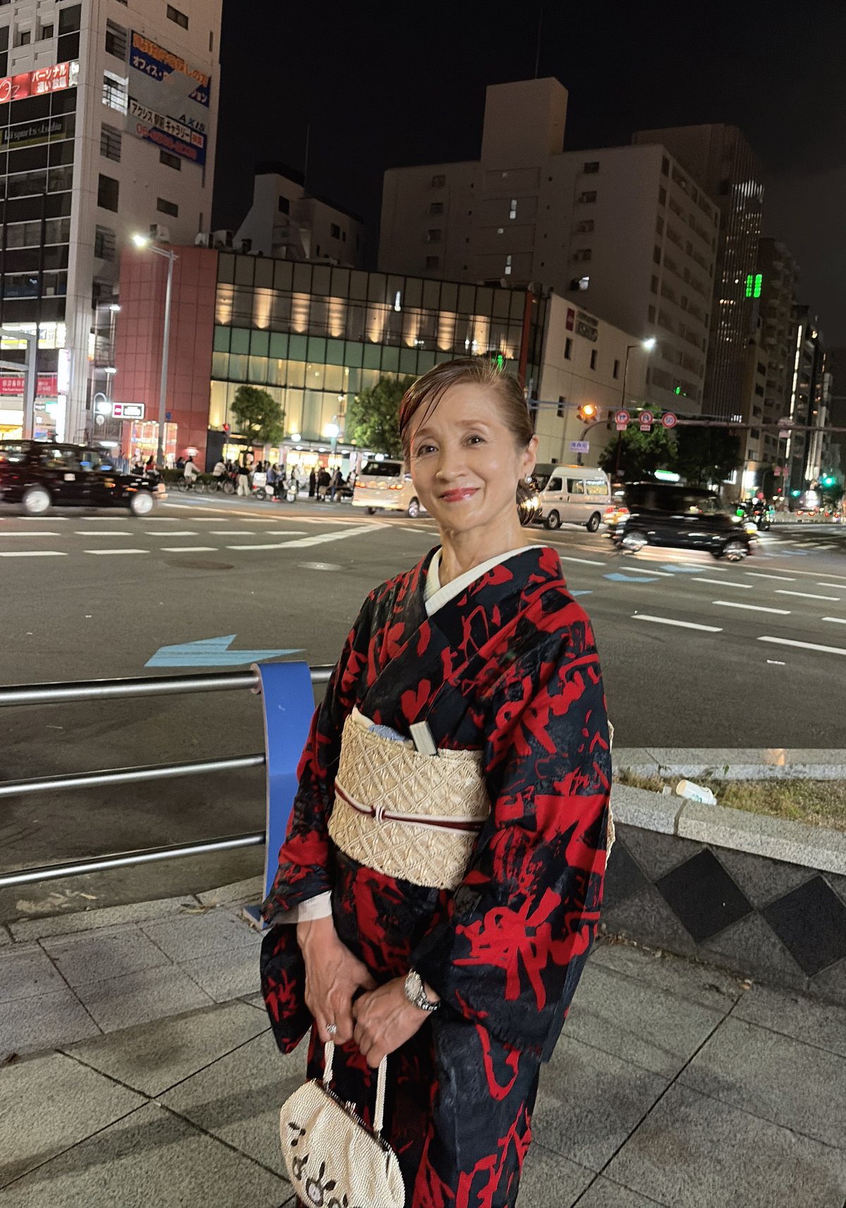 夜の街に立つ着物姿の人見惠子